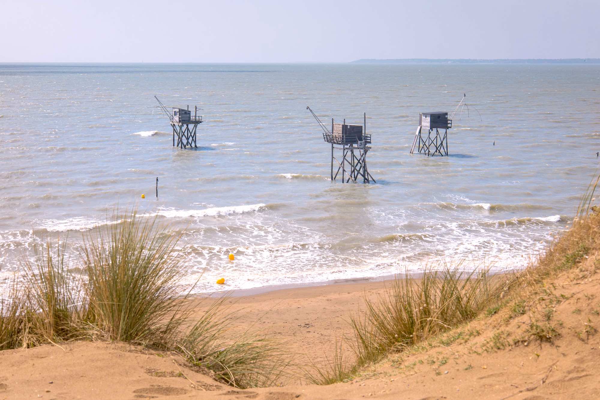 À 1 heure de Nantes, peu de gens connaissent les plages sauvages de Saint-Michel-Chef-Chef avec carrelets et dunes préservées background poster